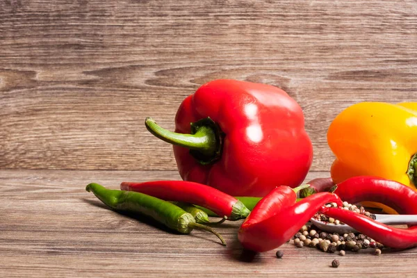 Stock image Sweet and hot pepper on wooden background. Healthy eating