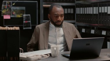 Dedektif, olay odasında polis arşiv kayıtlarıyla klasörü inceliyor. Özel dedektif dava dosyalarını okuyor, adli kanıtları ve tanık ifadelerini analiz ediyor..