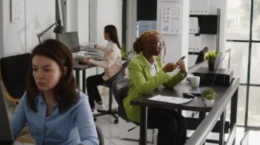 Şirket işinde telefonu kullanan, masa başı şirketine yatırım yapan kadın bir ofis çalışanı. Akıllı telefondan sosyal medyada gezinen yönetici yardımcısı, iş çözümleri üzerinde çalışıyor.