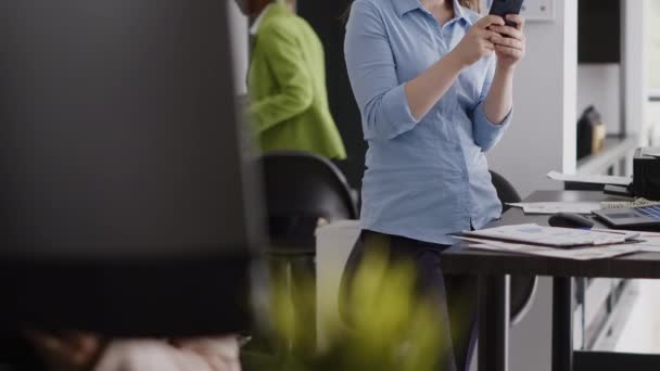 执行经理在办公室使用在线社交媒体应用程序浏览互联网上的手机 员工休息与计算机的年度报告规划 持有智能手机 — 图库视频影像