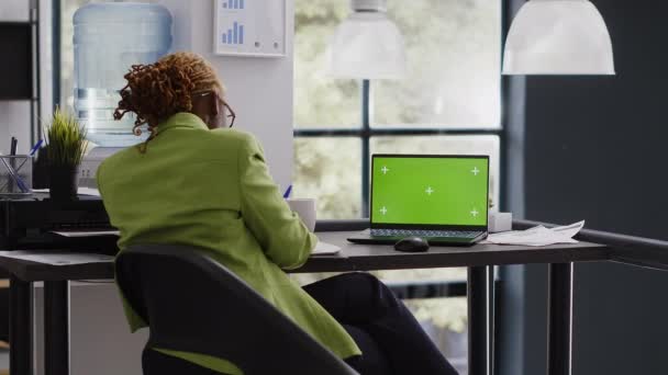 非洲裔美国妇女分析笔记本电脑与绿屏 使用孤立的显示在办公室办公桌 公司员工在行政工作中检查空白色键模型模板 — 图库视频影像