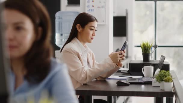 亚洲的办公室工作人员在工作场所使用智能手机应用程序 在工作前计划在线报告 在合作空间浏览互联网和社交媒体应用程序的年轻员工 — 图库视频影像