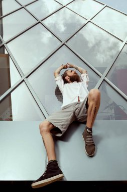 Tatoos ve ofis kameraya poz binası önünde uzun sakal ile cool görünümlü adam. Yaşam tarzı