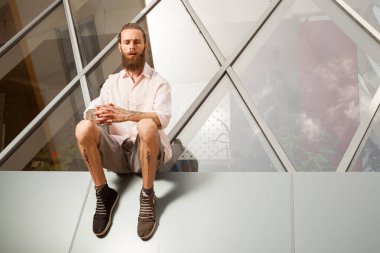 Hippi ofis binasının önünde poz veriyor. Modern şirket.