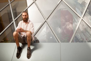 Hippi ofis binasının önünde poz veriyor. Modern şirket.