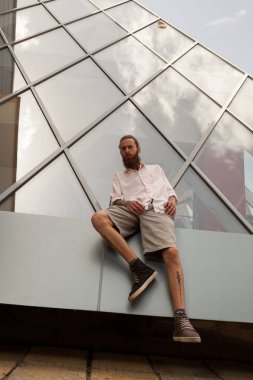 Serin dövmeli hipster ofis binası önünde poz sakallı. Modern şirket kurmak