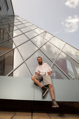 Serin dövmeli hipster ofis binası önünde poz sakallı. Modern şirket kurmak