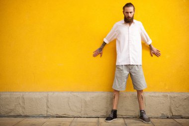 Sarı duvarda uzun sakallı hippi moda çekimlerinde