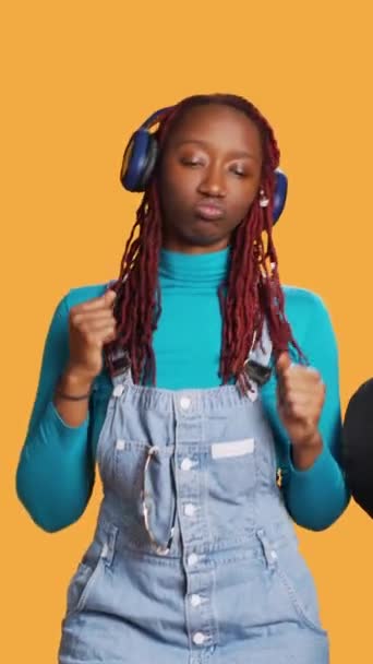 Vertikales Video Afroamerikanerin Schickt Luftküsse Und Hört Musik Über Kopfhörer — Stockvideo