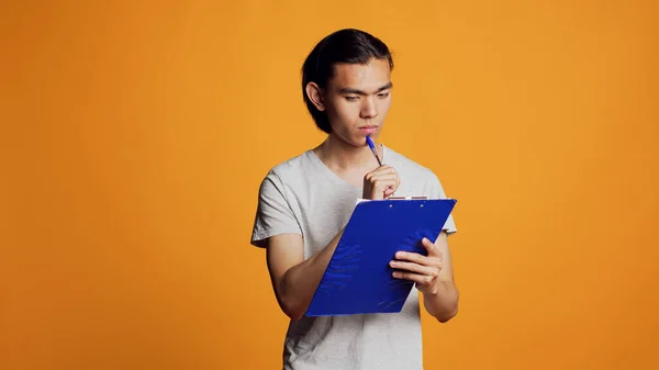 Confident Young Man Writing Taking Notes Files Using Clipboard Papers — Stockfoto