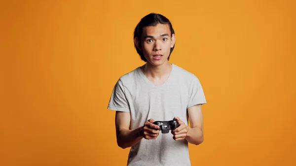 Modern Asian Man Playing Videogames Console Using Controller Joystick Have — Zdjęcie stockowe