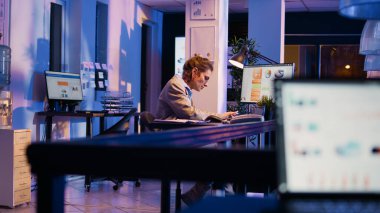 Genç yönetici sırt ağrısını dindirmek için ayakta duruyor. Ofisteki mali grafikler üzerinde çalışırken midesi bulanıyor. Danışman ajan mesai saatleri dışında masada oturduktan sonra vücudu geriyor. El kamerasıyla..