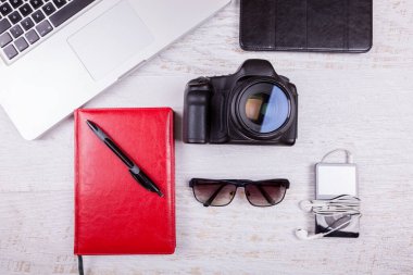 Dizüstü bilgisayar, dizüstü bilgisayar, kamera ve müzik çalar ahşap arka plan üzerine yazma