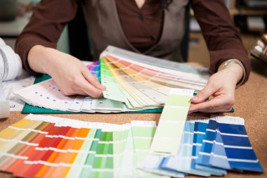 Mimar masasının üzerinde renk paleti ile kapatın. Yeni mimar ve tasarım planı üzerinde çalışıyor. Profesyonel mimari planları