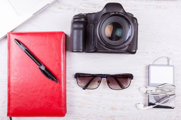 stock image Laptop, writing notebook, camera and musical player on wooden background