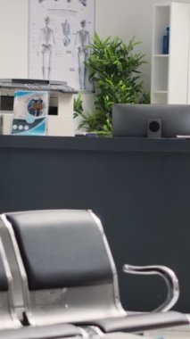 Dikey video: Koridor ve bekleme odasındaki hastane resepsiyonu, sağlık hizmetleri kliniğinde sağlık kontrolü. Klinik teşhis merkezinde koltukları olan bekleme alanı, acil servis..