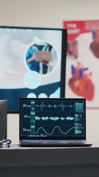 Vertical Video Empty Reception Desk Laptop Running Heart Rate Electrocardiogram — стоковое видео