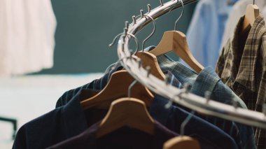 Askı ve askılarla dolu boş giyim pazarı, alışveriş merkezinde asılı modern resmi kıyafetler. İndirimli gömlekli moda butiği, küçük ticari faaliyet..