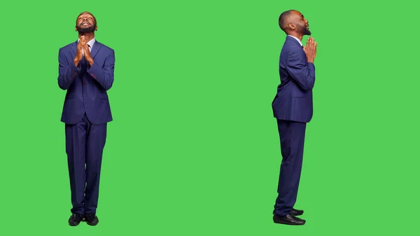 スタートアップ起業家は 緑の画面の背景に正式なスーツを着て スタジオで幸運のために神に祈る 祈りの印を手にした若い男性社員 宗教家 — ストック写真