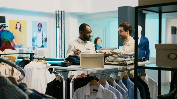 Kunde Und Mitarbeiter Betrachten Kleidungsstücke Die Laden Hängen Eine Verkäuferin — Stockfoto