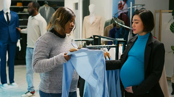 ショッピングモールのデパートで服のための赤ちゃんバンプのショッピングを持つアジアの女性は ハンガーに新しいファッションブランドを見て 若い将来の母親が妊娠中のショッピングセンターを訪問 — ストック写真
