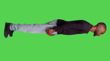 Dikey video: Afro-Amerikan bir adamın stüdyoda sabırsız bekleyip kamerada bir şeyler düşündüğü profil. Erkek beyin fırtınası yapıyor sabırla fikirler üretiyor, tüm vücudun üzerinde duruyor.