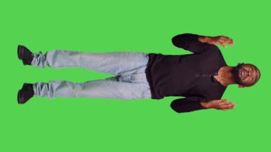 Dikey video: Stüdyoda İsa 'ya dua eden, dua eden ve af dileyen genç ruhani adamın ön görüntüsü. İnançlı dindar bir insan, tüm vücudunda iyimser bir yetişkin.