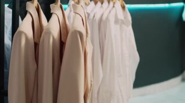 Alışveriş merkezindeki giyim mağazası, modern moda kıyafet koleksiyonu olan çeşitli markalar. Askılarda moda gömlekler ve pantolonlar, indirimler ve ticari faaliyetler..