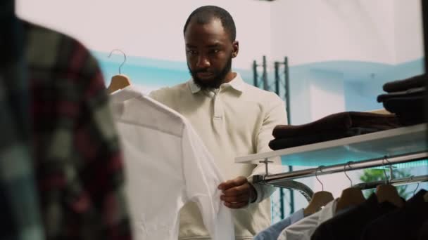 Afro Amerikaanse Cliënt Pikt Kleding Van Hangers Kijkt Naar Kledingwinkel — Stockvideo