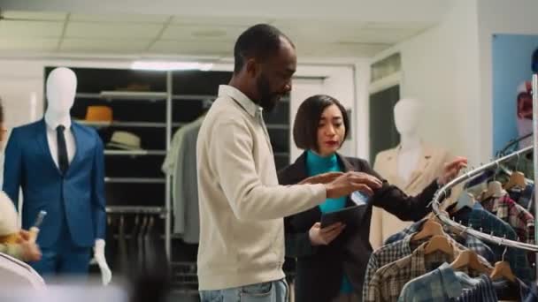 Diverse Leute Begutachten Kleidungsstücke Auf Regalen Zum Einkaufen Frauen Arbeiten — Stockvideo