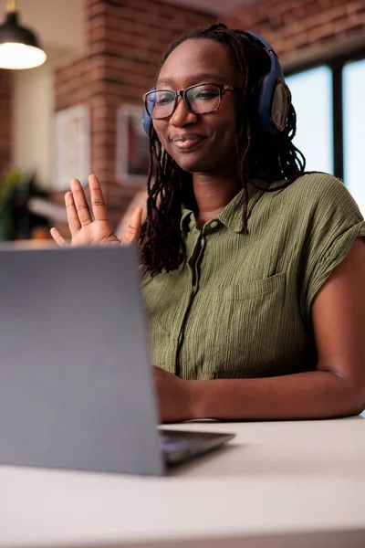 Portret Amerykańskiego Studenta Bezprzewodowymi Słuchawkami Wykonującego Gest Powitalny Podczas Wideokonferencji — Zdjęcie stockowe