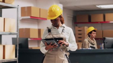 Tabletteki hisse senedi listesini analiz eden çok ırklı işçiler nakliye mallarına teslimat hizmeti kargosuna bakıyor. Envanter için barkodları tarayan gençler, endüstriyel tarayıcılar. El kamerasıyla..