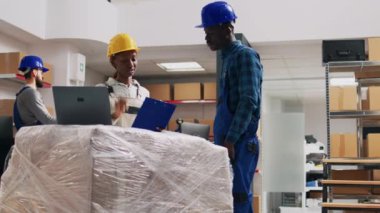 Depo çalışanları depo raflarına konan kutuları sayıyor, karton paketlerdeki malları naklediyor. Kadın ve erkek endüstriyel ürünleri analiz ediyor, depolama odası.