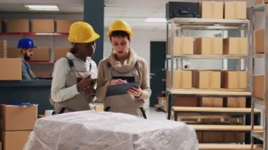 Çeşitli kadınlar depolama odasında ya da depolama alanında ürünleriyle dijital tablet envanteri çıkarıyorlar. Genç bir grup işçi stok malları ve teslimat servisiyle sipariş vermeyi planlıyor..