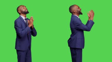 Ofis çalışanı takım elbiseli, Tanrı 'dan servet diliyor, dileğini yerine getirmek ve iyi şanslar dilemek için dua ediyor. Erkek şirket çalışanı dua ederken el ele tutuşuyor, yeşil ekranda dindar ve ruhani oluyor..