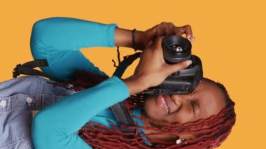 Dikey video: Fotoğrafçı şehir molasında resim çekiyor, kentsel hedefe gidiyor, mimari fotoğraf ve simgeleri yakalamak için dslr kamera kullanıyor. Genç yetişkin fotoğraf çekiyor. El kamerasıyla..