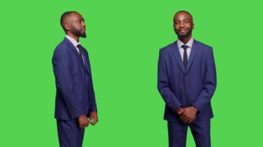 Stüdyoda takım elbiseli bir şirket çalışanı, izole edilmiş yeşil ekran arka planda poz veriyor. Erkek girişimci şirket işi yeşil ekran arkaplanı üzerinde poz veriyor, model.