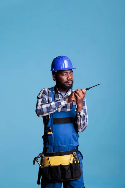 건축가가 무엇인가를 조립하는 과정에서 파란색 작업복을 보호용 헬멧을 집중적 표현으로 — 스톡 사진