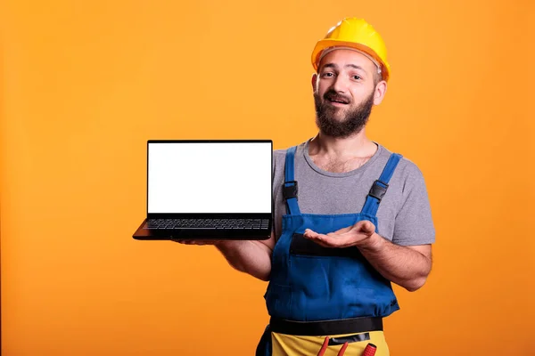 Vrolijke Bouwer Toont Laptop Met Wit Leeg Scherm Houdt Met — Stockfoto