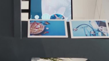 Dikey video: Tesisteki boş kayıt masası, sağlık kontrolleri ve klinik raporlarla dolu hastane resepsiyonu. Sağlık sigortası broşürleriyle bekleme salonu.
