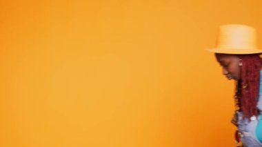 El arabası ve sırt çantası taşıyan bir kadın. Tatil için stüdyoya gidiyor. Havaalanında valiz ve bavulla seyahat eden neşeli bayan turist, boş zaman aktivitesi. El kamerasıyla..