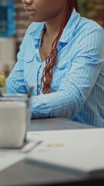 Dikey video: Yeni vizyon üzerinde çalışmak için çevrimiçi sonuçlar ve analizleri kullanarak iş karını artırmak için proje araştırması yapan kadın işçi. Kadın yönetici gazetelerde yıllık veri raporlarını okuyor.