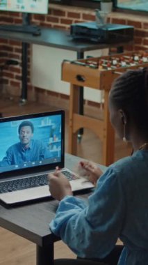 Dikey video: İş kadını laptopta video görüşmesi yapıyor, iş arkadaşlarıyla kâr geliştirme hakkında konuşuyor. İnternet üzerinden yapılan telekonferans görüşmesine katılan kadın ofis çalışanı.