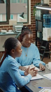 Dikey video: Öfkeli adamın dosyaları toplantı odasına atması, ekibin yeni geliştirme planı elde edememesi üzerine stres hissetmesi. Afrika kökenli Amerikalı yönetici ofis işleri yüzünden kızgın ve hayal kırıklığına uğramış.