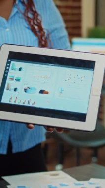 Dikey video: İnsanlar masadaki çevrimiçi sonuçları gözden geçiriyorlar, veri analizi ve raporlarıyla iş projesi oluşturmak için toplanıyorlar. Yönetim uzmanlığına sahip personel takımı karı artırmaya çalışıyor