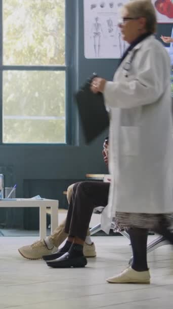 Pionowe Wideo Lekarz Trzymający Butelkę Witamin Poczekalni Szpitalnej Wyjaśniając Leczenie — Wideo stockowe