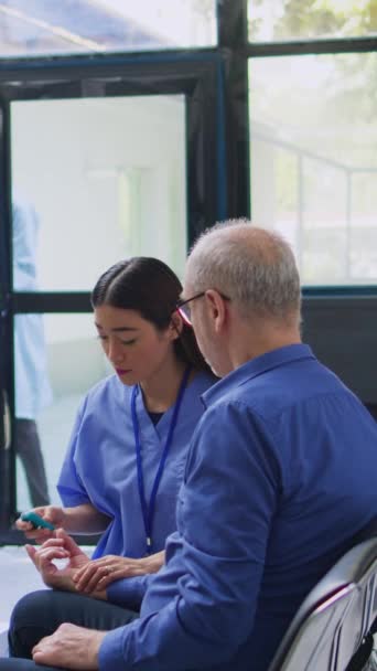 Вертикальное Видео Азиатская Медсестра Консультирует Пожилого Пациента Глюкометром Время Консультации — стоковое видео