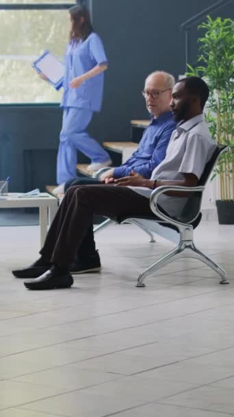 Вертикальное Видео Разные Люди Сидят Стульях Приемном Покое Больницы Ожидая — стоковое видео