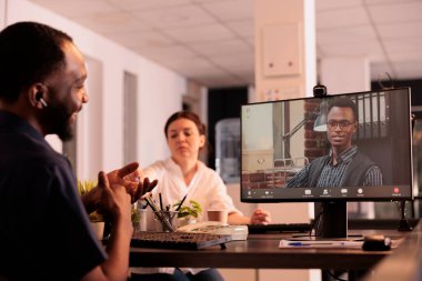 Uzaktan kumandalı iş arkadaşları bilgisayardaki webcam yazılımını kullanarak kurumsal video görüşmesi yapıyor, çalışanlar online toplantıda iş planını tartışıyor. İş adamı video konferansında meslektaşını dinliyor