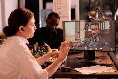 Meslektaşlar bilgisayardaki şirket toplantılarında sohbet ediyorlar, çalışanlar iş planlarını video çağrı uygulaması kullanarak tartışıyor. Yetkili müdür telekonferans brifinginde konuşuyor.